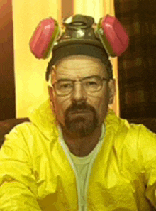 a man with a beard wearing a yellow jacket and a helmet .