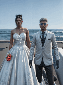 a bride and groom standing next to each other in front of a body of water