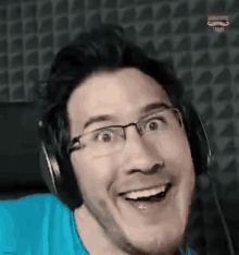 a man wearing glasses and headphones is smiling while making a funny face .