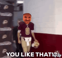 a man in a football uniform is walking down a hallway with the words `` you like that '' behind him .