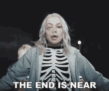 a woman wearing a skeleton shirt with the words the end is near below her