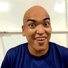 a bald man is smiling and making a funny face .