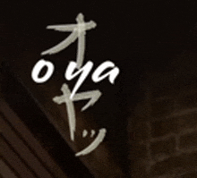 a close up of a sign that says `` oya '' on a black background .