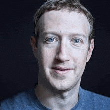 a close up of a man 's face with a blue shirt on and a black background .