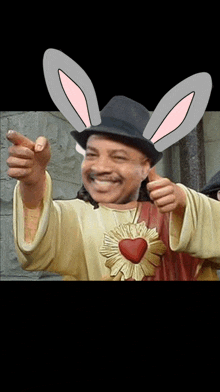 a man wearing bunny ears and a hat is pointing