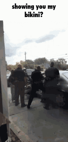 a group of police officers are standing in front of a car and a sign that says showing you my bikini