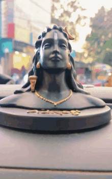 a statue of shiva sits on the dashboard of a black car