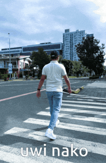 a man walking across a street with the words uwi nako written on the bottom