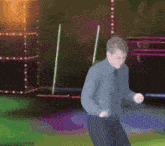 a man is dancing in front of a stage with lights