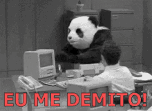 a man is sitting at a desk with a panda mask on and the words eu me demi to the bottom .