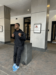 a man is standing in front of a marriott hotel in philadelphia