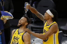 a basketball player with the number 30 on his jersey is being poured with water