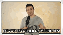 a man is holding a microphone and saying eu vou escolher os melhores !