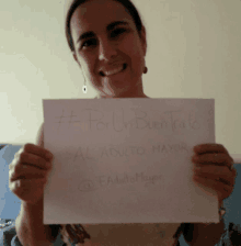 a woman holds up a sign that says " por un buen trao "