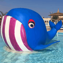 a blue and pink whale is in a pool