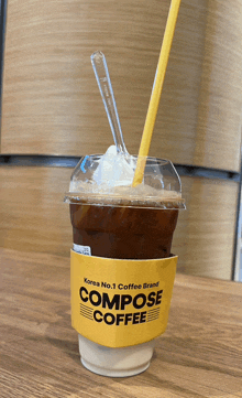 a cup of compose coffee with whipped cream and a straw