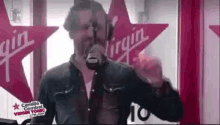 a man is singing into a microphone in front of a red star .