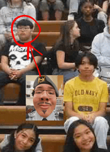 a boy wearing an old navy shirt sits in a crowd