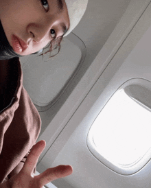 a person wearing a beanie is sitting in an airplane