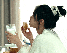 a woman with a cross tattoo on her wrist is drinking milk and eating bread