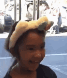 a little girl wearing a headband with ears on it