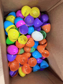 a cardboard box filled with lots of colorful plastic eggs