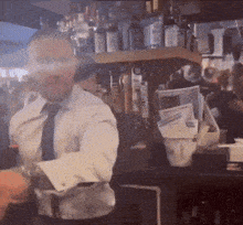 a man in a white shirt and tie is standing in front of a bar with bottles of jack daniels on the shelf