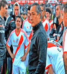 a man stands in front of a group of soccer players one of whom is wearing a jersey that says petrobras