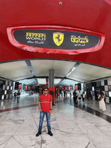 a man stands in front of a sign for the ferrari world