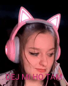 a girl wearing pink headphones with cat ears says " dej mi ho tam " on the bottom