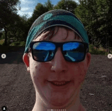 a young man wearing sunglasses , a headband and a beanie is smiling for the camera .