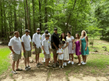 a group of people posing for a picture in a forest