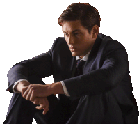 a man in a suit and tie is sitting on the floor