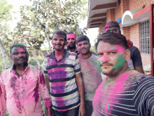 a group of men with their faces painted with pink and green powder