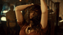 a woman in a red top is dancing with her arms in the air