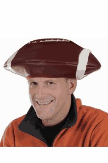 a man wearing a hat that looks like a football is smiling