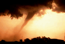 a tornado is swirling through a sunset sky