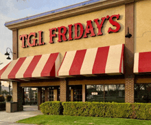 a restaurant called tgi friday 's with a red and white awning