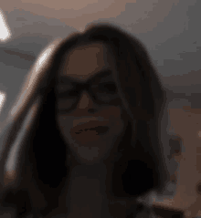 a blurry photo of a woman wearing glasses and a mask