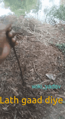 a person holding a stick in the dirt with the words ' hath gaad diye ' on the bottom right