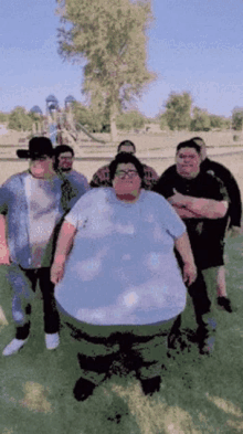 a group of fat men are posing for a picture in front of a playground ..