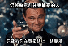 a man in a tuxedo is holding a glass of wine with chinese writing behind him