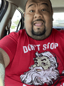 a man is wearing a red shirt that says " don t stop "