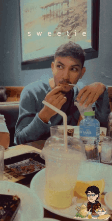 a man sitting at a table with a straw in his mouth and the word sweetie on the top