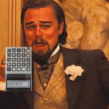 a man in a tuxedo is holding a calculator that says boobies