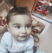 a baby with arabic writing on the bottom of her face