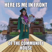 a woman in a graduation cap and gown is standing on a dock in front of a community house holding flowers .