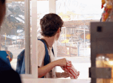 a man holding a bag of popcorn in front of a window with a sign that says ' ferris wheel ' on it