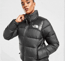 a woman is wearing a black north face puffer jacket