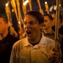 a man is holding a torch in a crowd of people at a protest .